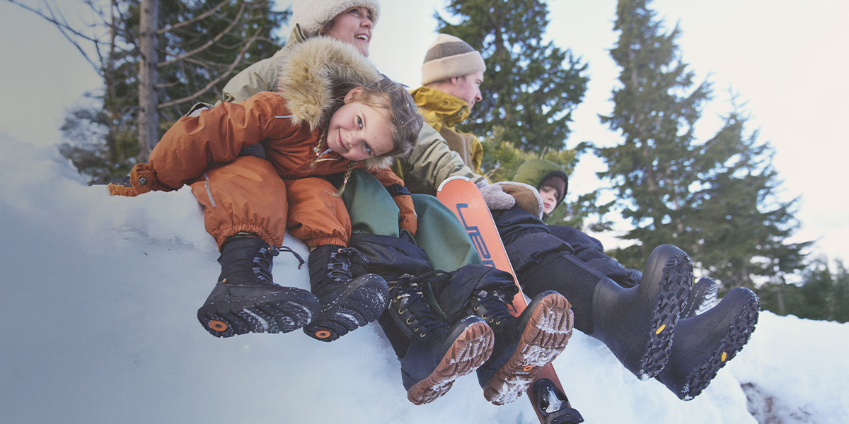Shop this seasons best sellers featuring a family sitting on a snowbank.