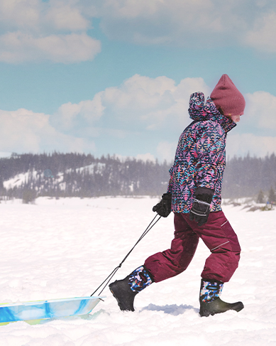 Shop the Kids' York Seamless featuring a child pulling a sled in the snow.