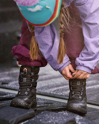 Shop the kids Skyline Snowcata featuring a girl putting on the boots.
