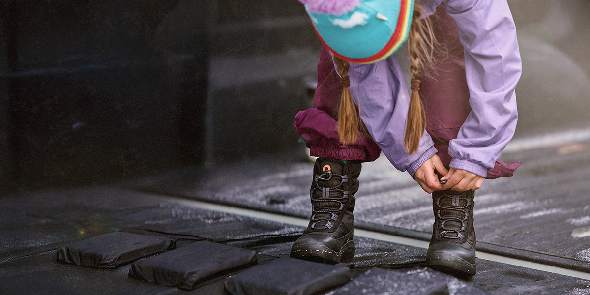 Shop the kids Skyline Snowcata featuring a girl putting on the boots.