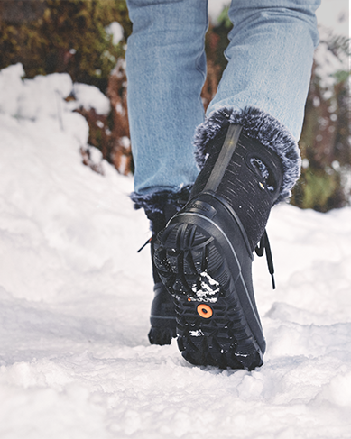 Shop Bogs Women's winter boots featuring the Arcata Dash walking in the snow.