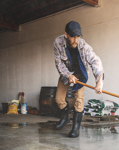 Shop the men's Bozeman II featuring a man cleaning his garage. 
