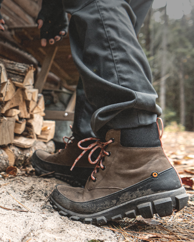 Shop our sale section featuring a brown lace up boot next to a wood pile.