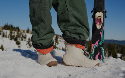 For Women. Image shows a women in her Boga Boots standing in the snow with ski's.